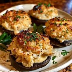 three stuffed mushrooms with cheese and parsley on a plate