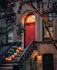 a red door and some stairs with pumpkins on the steps in front of it