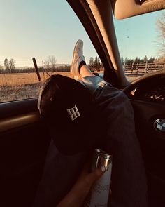 a person sitting in the back seat of a car with their feet on the steering wheel