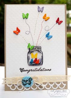 a handmade card with butterflies flying out of a jar on top of a table