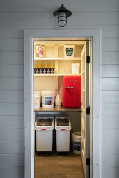 an open door shows the inside of a small storage unit with bins and containers in it