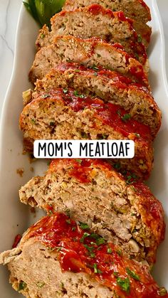 slices of meatloaf on a white platter with ketchup and garnish