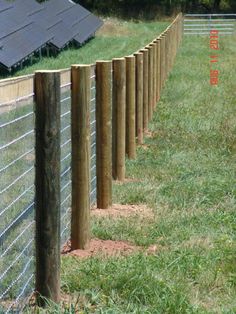 a row of wooden posts next to a fence