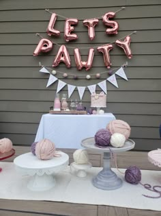 a party with balloons, cake and yarn on the table for it's birthday