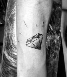 a black and white photo of a man's arm with an origami tattoo on it