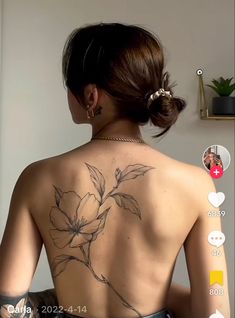 the back of a woman's body with tattoos on her upper and lower back