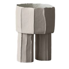 three different colored vases sitting next to each other on a white surface, one is made out of cardboard