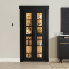 a tall black cabinet with glass doors in a room