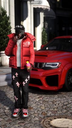 a man in red jacket standing next to a red car and talking on a cell phone