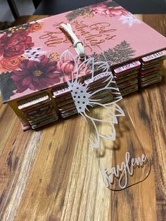 an open book on a wooden table with flowers and words cut out of the pages