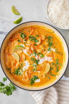 a large pan filled with shrimp, rice and cilantro sauce on top of a table