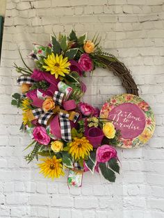 a wreath on the wall with sunflowers, roses and other flowers around it