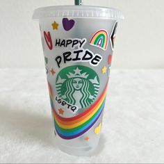 a starbucks cup with the words happy pride on it and a rainbow - striped straw