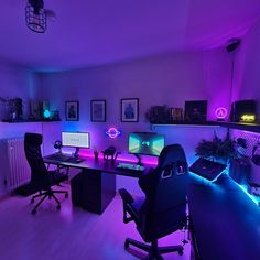 a room with two computers and purple lighting