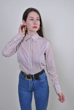 "White striped shirt, vintage formal blouse, Size M Welcome to TARASCOMMON.ETSY.COM Unique clothing from the 20th century. Model tall 170cm. Size: M. Sleeve - 60cm / 23.62inch; Width - 40cm / 15.74inch; Length - 67cm / 26.37inch. COTTON. All measurements are taken seam to seam while lying flat. This item is vintage, so it can have some defects. Additional photos can be send! We are glad that you are interested in lots that we sell. Wish you a good shopping! FOLLOW US : Instagram:https://www.inst Classic Formal Blouse With Striped Collar, Classic Striped Shirt For Fall, Fitted Vertical Stripes Office Shirt, Classic Long Sleeve Blouse With Vertical Stripes, Classic Pinstripe Blouse With Striped Collar, Classic Fitted Brown Blouse, Retro Button-up Formal Shirt, Fitted Button-up Blouse With Vertical Stripes, Vintage Brown Shirt For Workwear