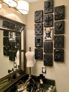 there are many black tiles on the wall in this bathroom that is decorated with skulls and hearts