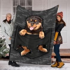 two women standing in front of a christmas tree with a large black and brown dog sticking its tongue out