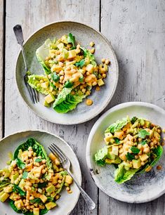 two plates filled with salad on top of a wooden table