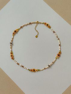 This necklace features different shades of hand woven yellow sunflowers and fall colors of cream, brown, green, and gold.  Length: 16.5- 19inches Seed Bead Size: 11/0, 6/0 This dainty piece is made up of high quality seed beads including 24kt gold plated beads, crystals, and tigers eye. Adjustable: Each necklace has a 2.5" gold filled lobster clasp extender Strung on: Non-Stretchy Beading Thread Brown Beaded Necklace, Fall Bead, Friendship Bracelets Designs, Yellow Sunflowers, Beading Thread, Bracelets Design, Sunflower Necklace, Bee Necklace, 24kt Gold