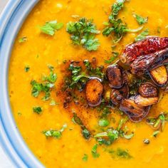 a blue bowl filled with soup and garnishes