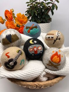 a basket filled with rocks covered in different types of embroidered designs on top of a white blanket