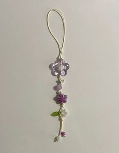 a purple and white flower hanging from a hook