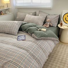 a bed room with a neatly made bed and a stuffed animal on the side table