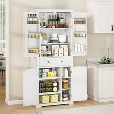 a kitchen with white cabinets and shelves filled with food