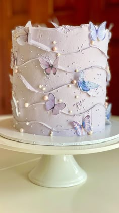 there is a white cake with butterflies on it