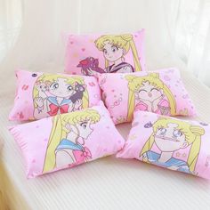 four pillows with princesses on them sitting on a bed