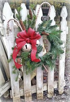 a christmas wreath on top of a wooden fence