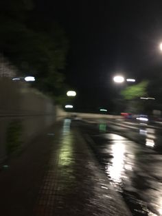 the street is wet and dark at night