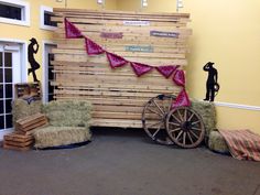 hay bales stacked on top of each other in front of a wall with a sign