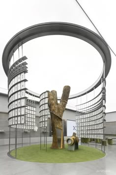 an artistic sculpture in the middle of a circular area with buildings in the back ground