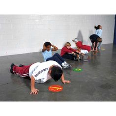 several children are playing with frisbees on the floor