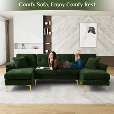 a woman laying on top of a green couch