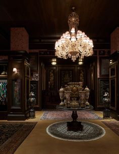 a fancy room with chandelier and rugs on the floor in front of it