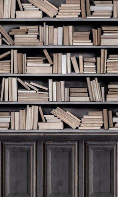 a bookshelf filled with lots of books on top of wooden shelves next to each other