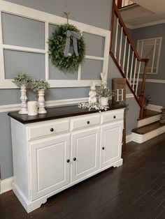 a white dresser sitting in the middle of a living room