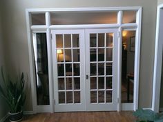 an empty room with white doors and wooden floors