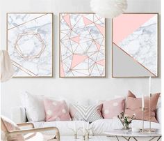 three paintings on the wall above a couch in a living room with pink and white decor