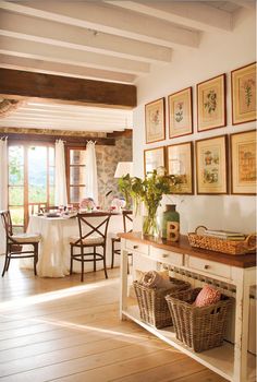 a dining room with pictures on the wall and table in front of it's windows