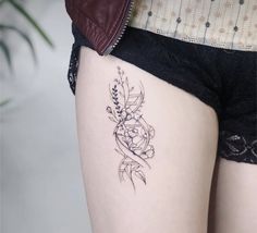 a woman's thigh with a flower tattoo on her left side, next to a potted plant