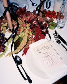 the table is set with an elegant menu and place setting for two people to eat