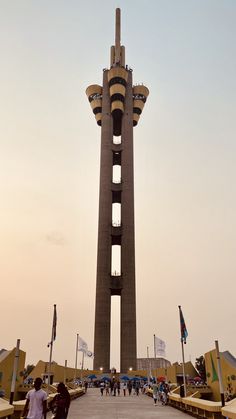 people walking around in front of a tall tower