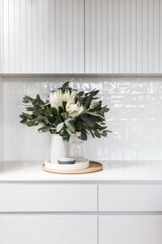 a vase with flowers sitting on top of a counter