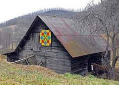 an old barn with a quilt on the roof