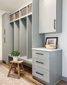 an empty room with some gray cabinets and a plant in the corner next to it