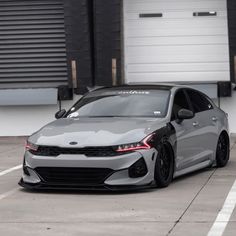 a grey car parked in front of a garage