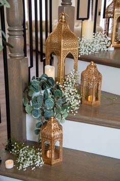 candles and flowers are on the stairs in front of lanterns, greenery, and other decorations